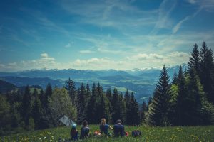 A family sits and admires a range of mountains.