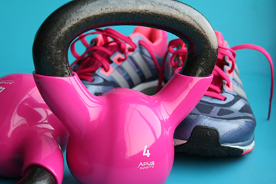 Dumbbells and a kettle bell sit beside sneakers.